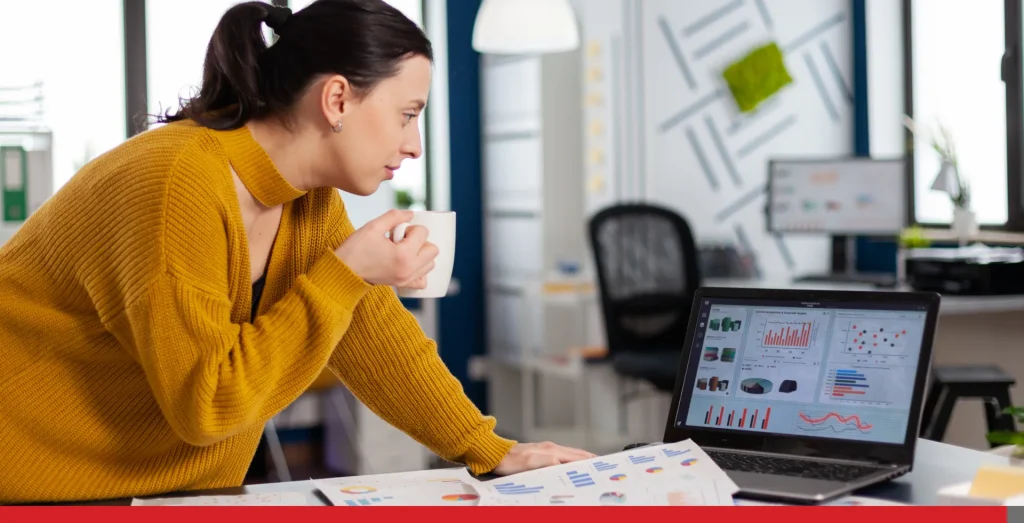 Woman working on her computer drinking coffee.